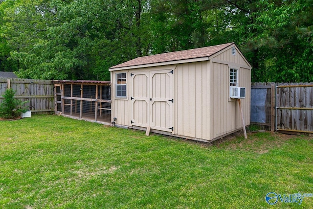view of shed featuring exterior structure, cooling unit, and a fenced backyard