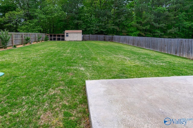 view of yard with a fenced backyard, a storage unit, and an outbuilding