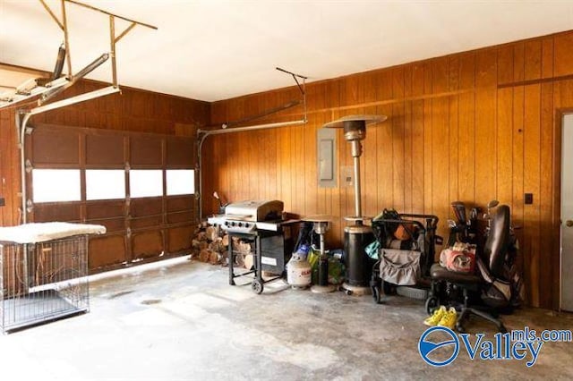 garage with electric panel and wood walls
