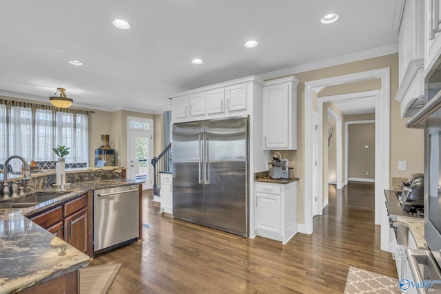 kitchen with dark stone countertops, white cabinetry, sink, and appliances with stainless steel finishes