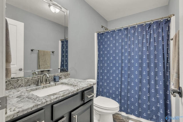 bathroom with toilet, vanity, tile patterned floors, and walk in shower