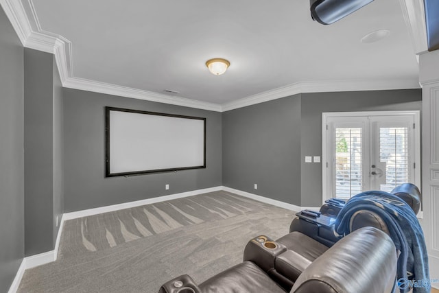 carpeted home theater room with french doors and ornamental molding