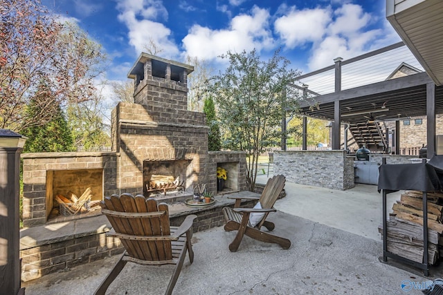 view of patio / terrace featuring ceiling fan and an outdoor fireplace