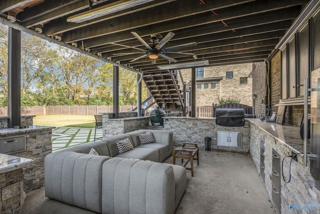 view of patio / terrace with outdoor lounge area, an outdoor kitchen, and a grill