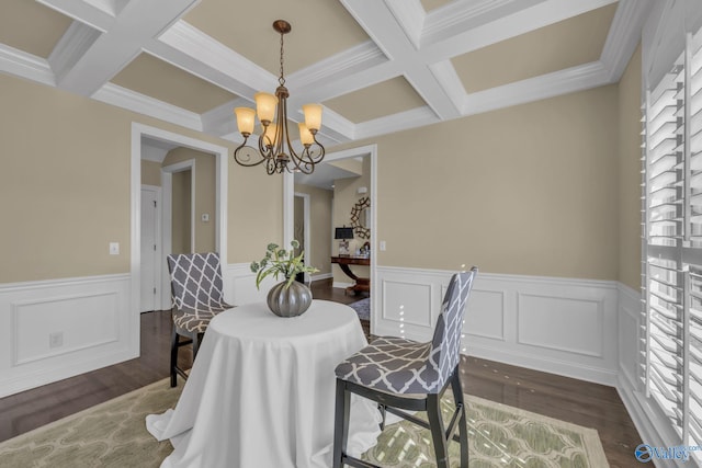 dining area with ornamental molding, dark hardwood / wood-style flooring, coffered ceiling, and a notable chandelier