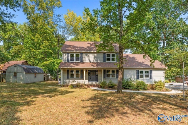 view of front of home with a front lawn and a shed