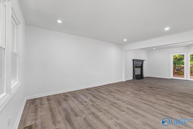 unfurnished living room featuring a premium fireplace and light hardwood / wood-style floors