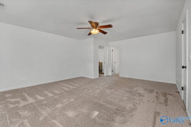 carpeted spare room with a textured ceiling and ceiling fan