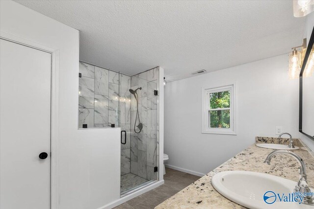 bathroom with walk in shower, toilet, a textured ceiling, and vanity