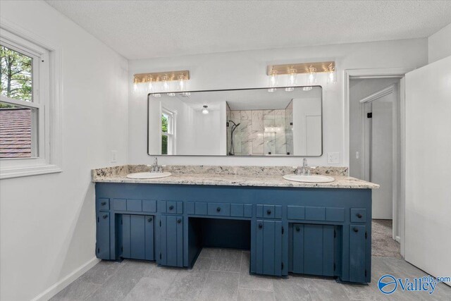 bathroom featuring vanity, a textured ceiling, and walk in shower