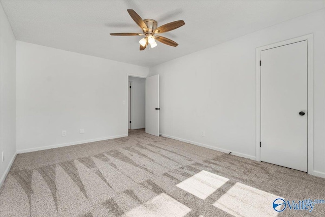 spare room featuring light colored carpet and ceiling fan