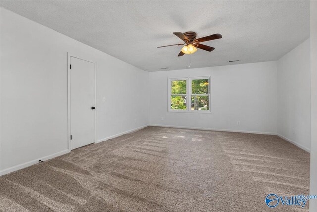 carpeted spare room featuring a textured ceiling and ceiling fan