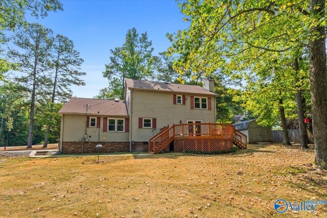 back of property featuring a wooden deck, a storage unit, and a yard