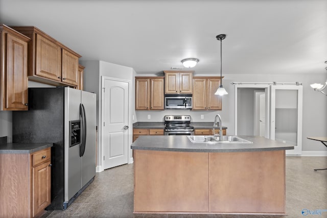 kitchen with stainless steel appliances, a barn door, sink, and decorative light fixtures