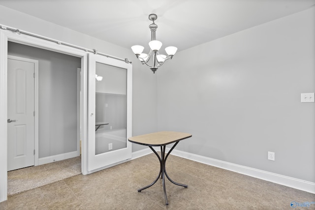 dining room with a barn door and a chandelier