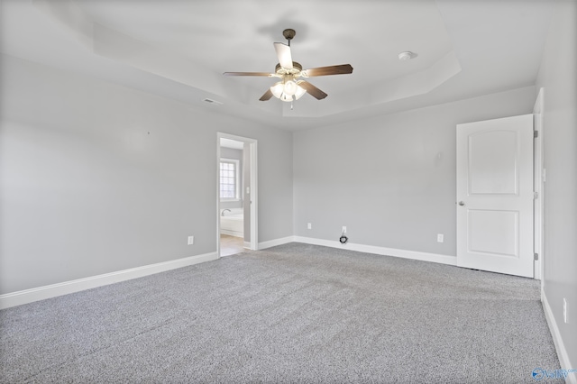 unfurnished room with light carpet, a raised ceiling, and ceiling fan