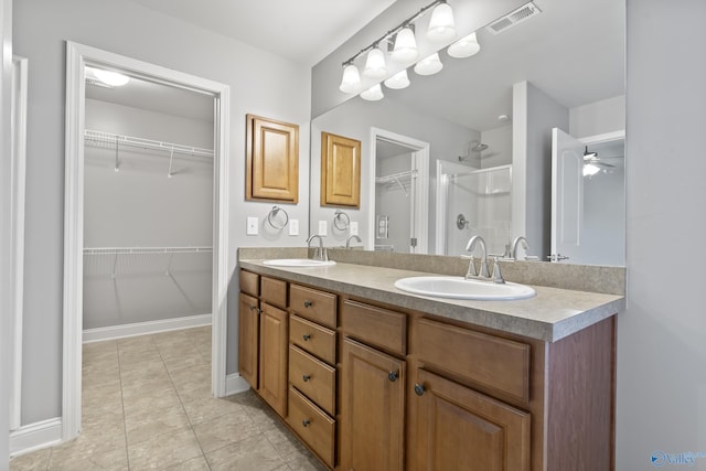 bathroom with vanity, tile patterned flooring, ceiling fan, and walk in shower