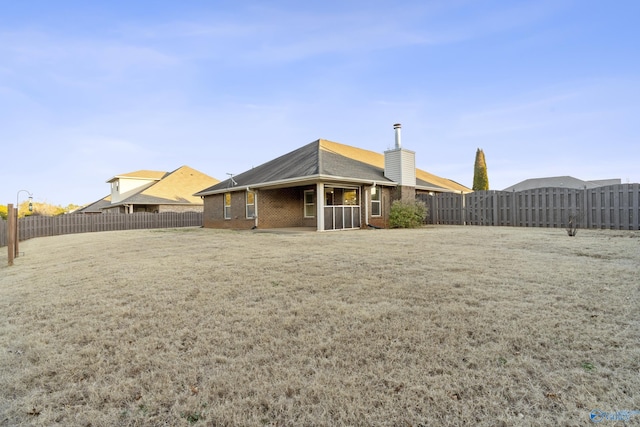 rear view of house featuring a yard