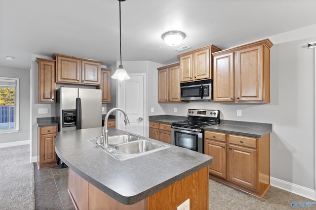 kitchen with appliances with stainless steel finishes, sink, an island with sink, and hanging light fixtures