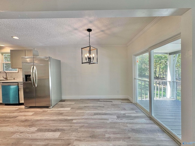 unfurnished dining area featuring light hardwood / wood-style floors, ornamental molding, sink, and a textured ceiling