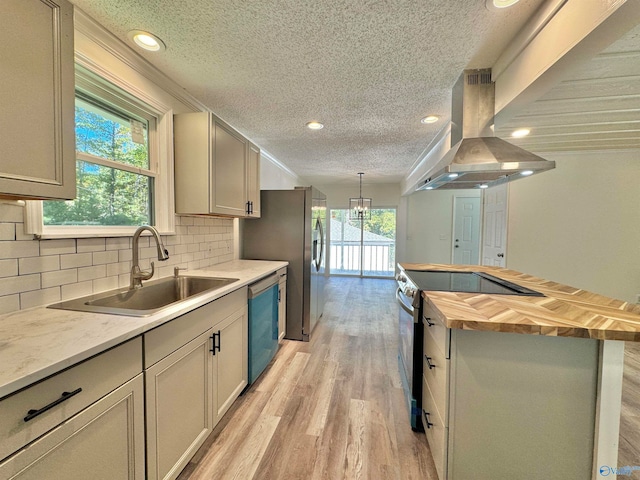 kitchen featuring tasteful backsplash, extractor fan, sink, light hardwood / wood-style floors, and stainless steel appliances