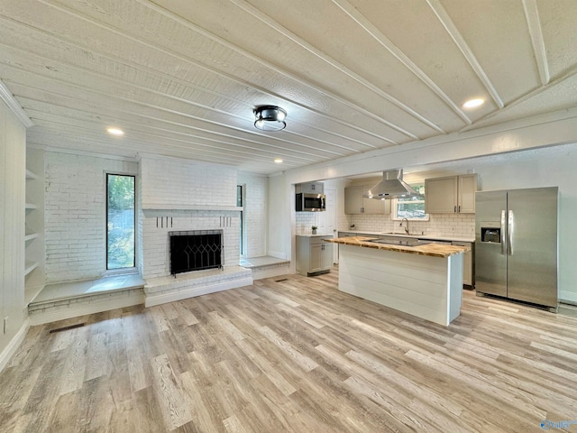 kitchen featuring appliances with stainless steel finishes, wood counters, sink, light hardwood / wood-style floors, and a center island