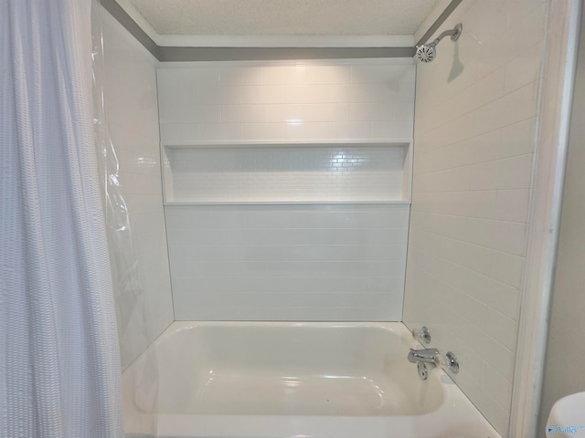 bathroom with shower / tub combo with curtain and a textured ceiling