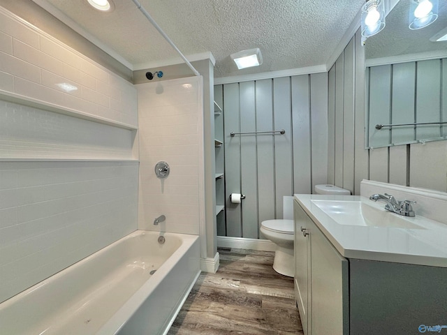 full bathroom with hardwood / wood-style flooring, toilet, shower / tub combination, vanity, and a textured ceiling