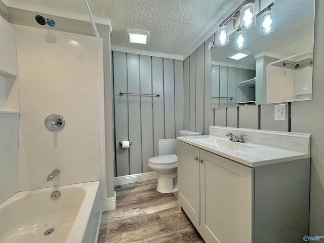 full bathroom with bathtub / shower combination, a textured ceiling, toilet, vanity, and hardwood / wood-style flooring