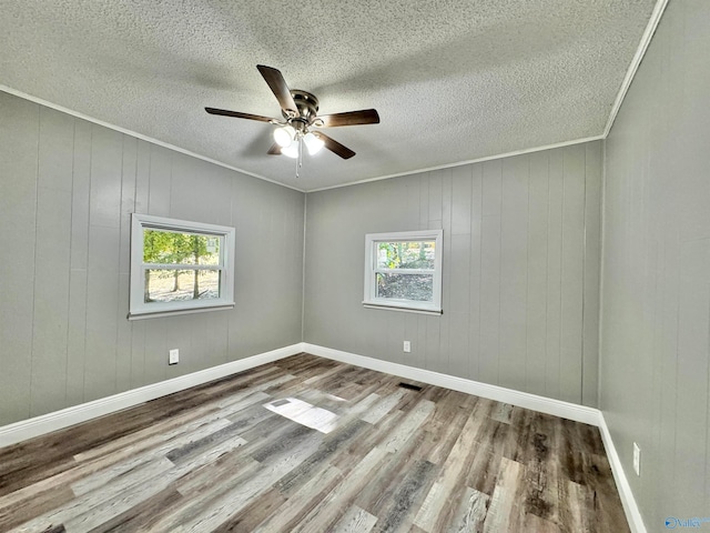 unfurnished room featuring hardwood / wood-style floors, a healthy amount of sunlight, a textured ceiling, and ceiling fan