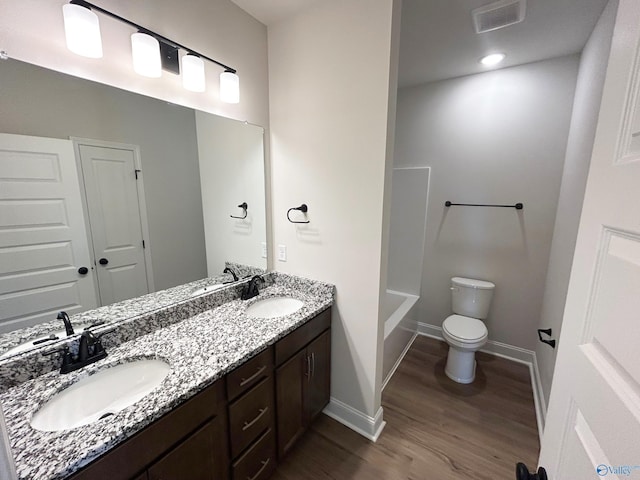 24081 Quints Dr, Athens, AL 35613 - bathroom with wood finished floors, double vanity, toilet, baseboards, and bathtub / shower combination