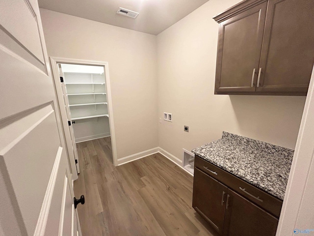 24081 Quints Dr, Athens, AL 35613 - laundry area featuring electric dryer hookup, cabinet space, washer hookup, wood finished floors, and baseboards