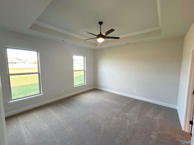 carpeted empty room featuring a raised ceiling and ceiling fan