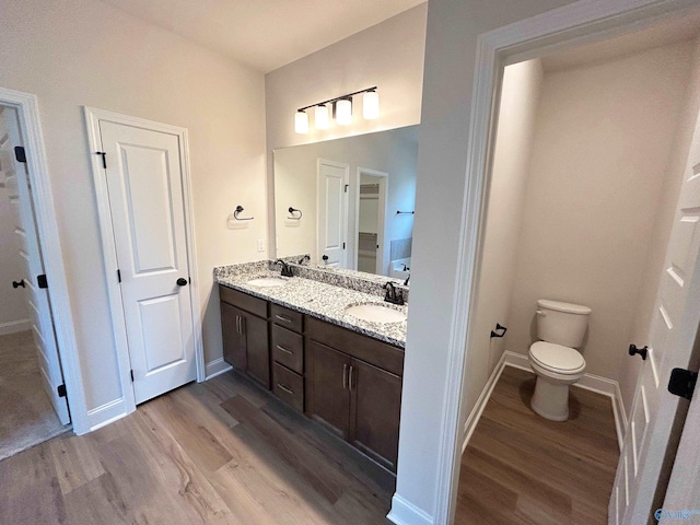 bathroom with wood-type flooring, toilet, and vanity