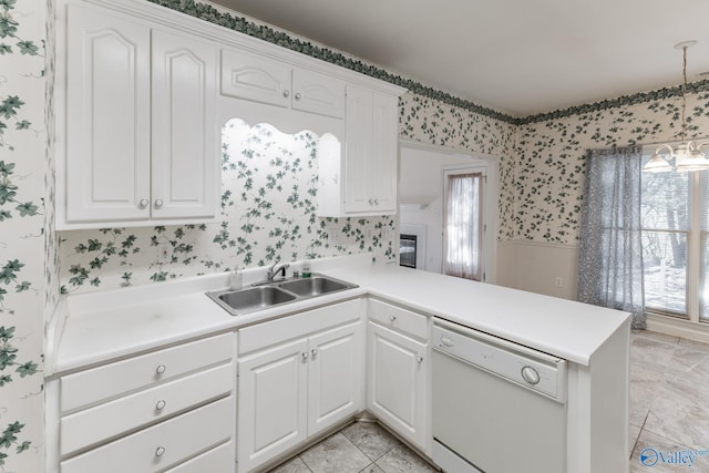 kitchen featuring white dishwasher, sink, white cabinetry, and kitchen peninsula