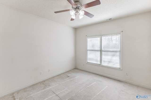 unfurnished room with a textured ceiling, ceiling fan, and light colored carpet