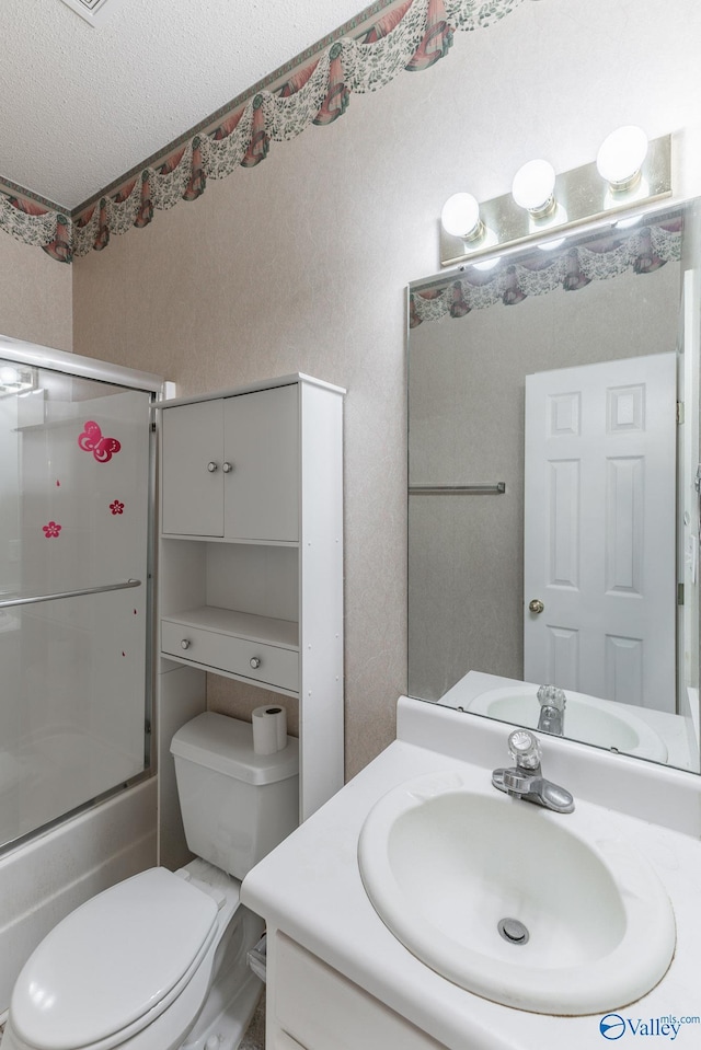 full bathroom featuring toilet, vanity, shower / bath combination with glass door, and a textured ceiling