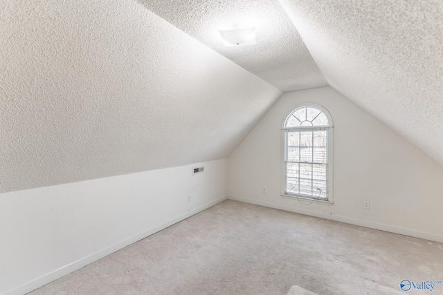 bonus room with light carpet, a textured ceiling, and lofted ceiling