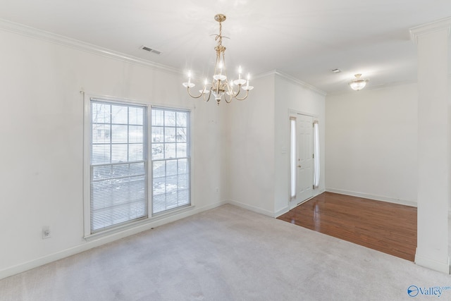 carpeted spare room featuring a chandelier and crown molding