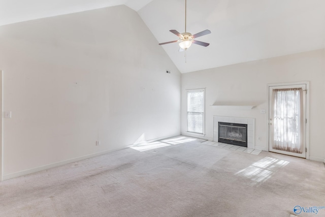 unfurnished living room featuring ceiling fan, light colored carpet, a tile fireplace, and high vaulted ceiling