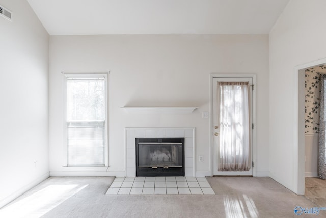 unfurnished living room featuring light colored carpet, vaulted ceiling, and a fireplace