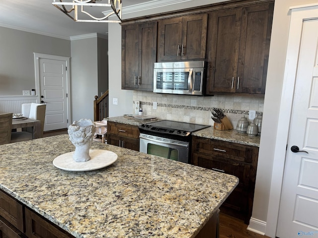 kitchen featuring dark brown cabinetry, appliances with stainless steel finishes, backsplash, light stone countertops, and crown molding