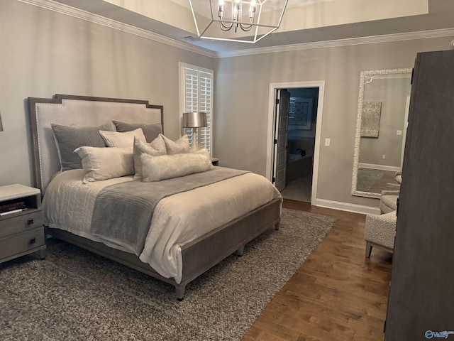 bedroom with a tray ceiling, a notable chandelier, ornamental molding, wood finished floors, and baseboards