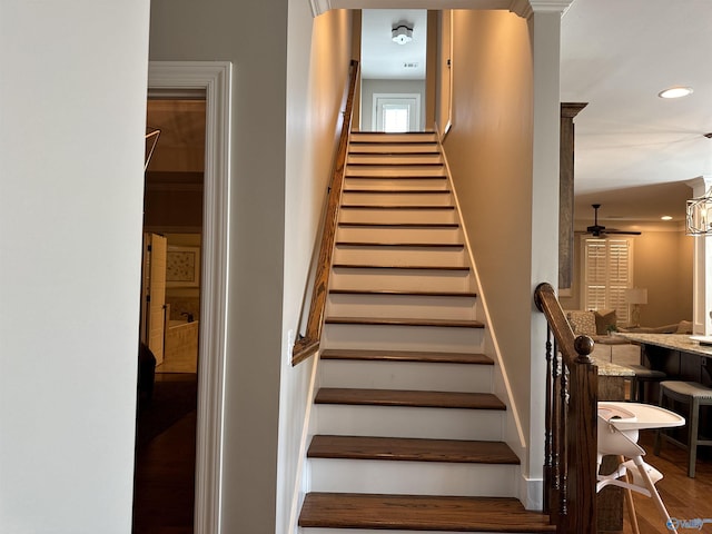 stairway with ceiling fan, wood finished floors, decorative columns, and recessed lighting