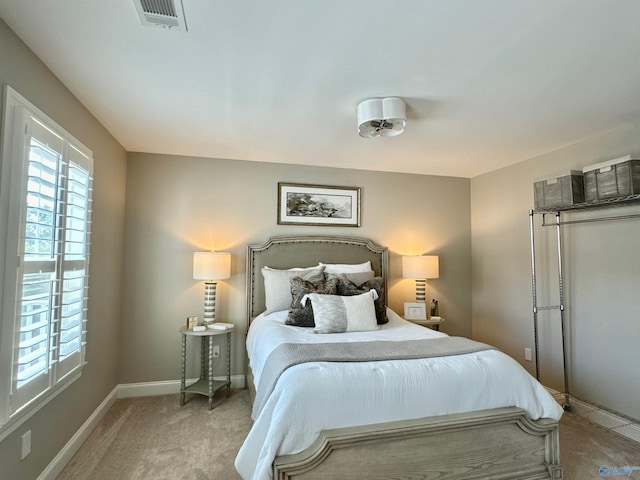 bedroom featuring carpet floors, multiple windows, visible vents, and baseboards