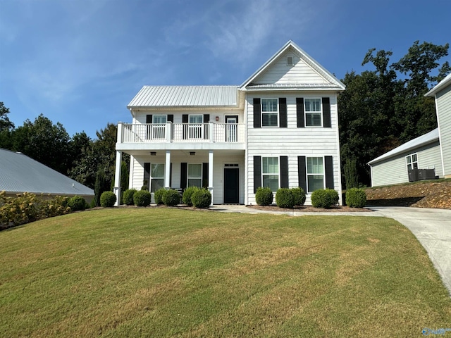 view of front of property featuring a porch, metal roof, a balcony, and a front lawn