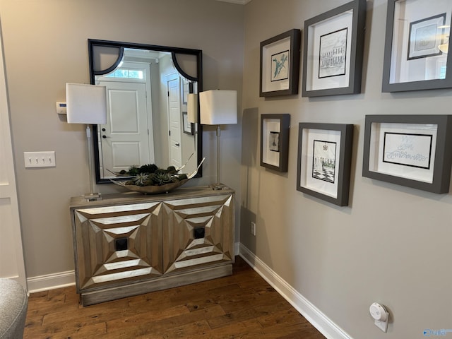 corridor with dark wood finished floors and baseboards