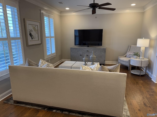 living area with baseboards, hardwood / wood-style floors, visible vents, and crown molding