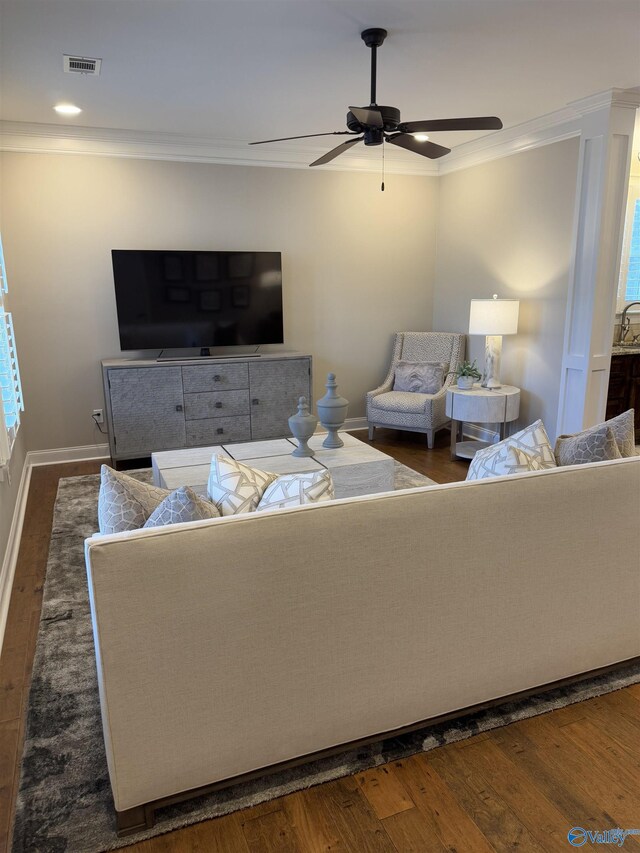 kitchen with a kitchen island, sink, ornamental molding, stainless steel appliances, and light stone countertops