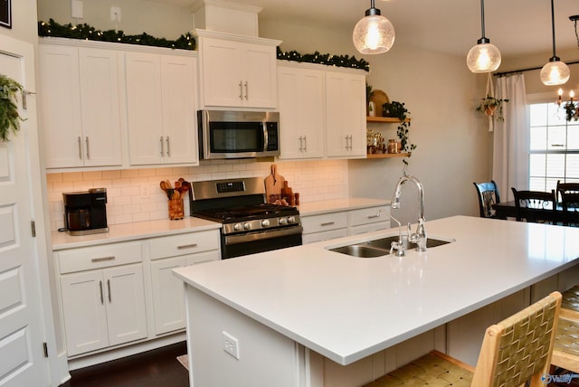 kitchen featuring pendant lighting, a kitchen island with sink, sink, and stainless steel appliances